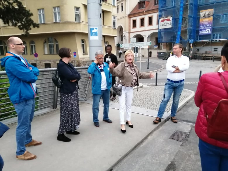 Grupa zwiedzających słuchająca kobiety przewodnika